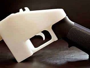 A 3D printed firearm frame with a black grip and a white body.